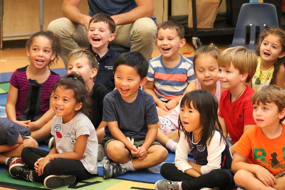 Group of children sitting on the floor, looking forward