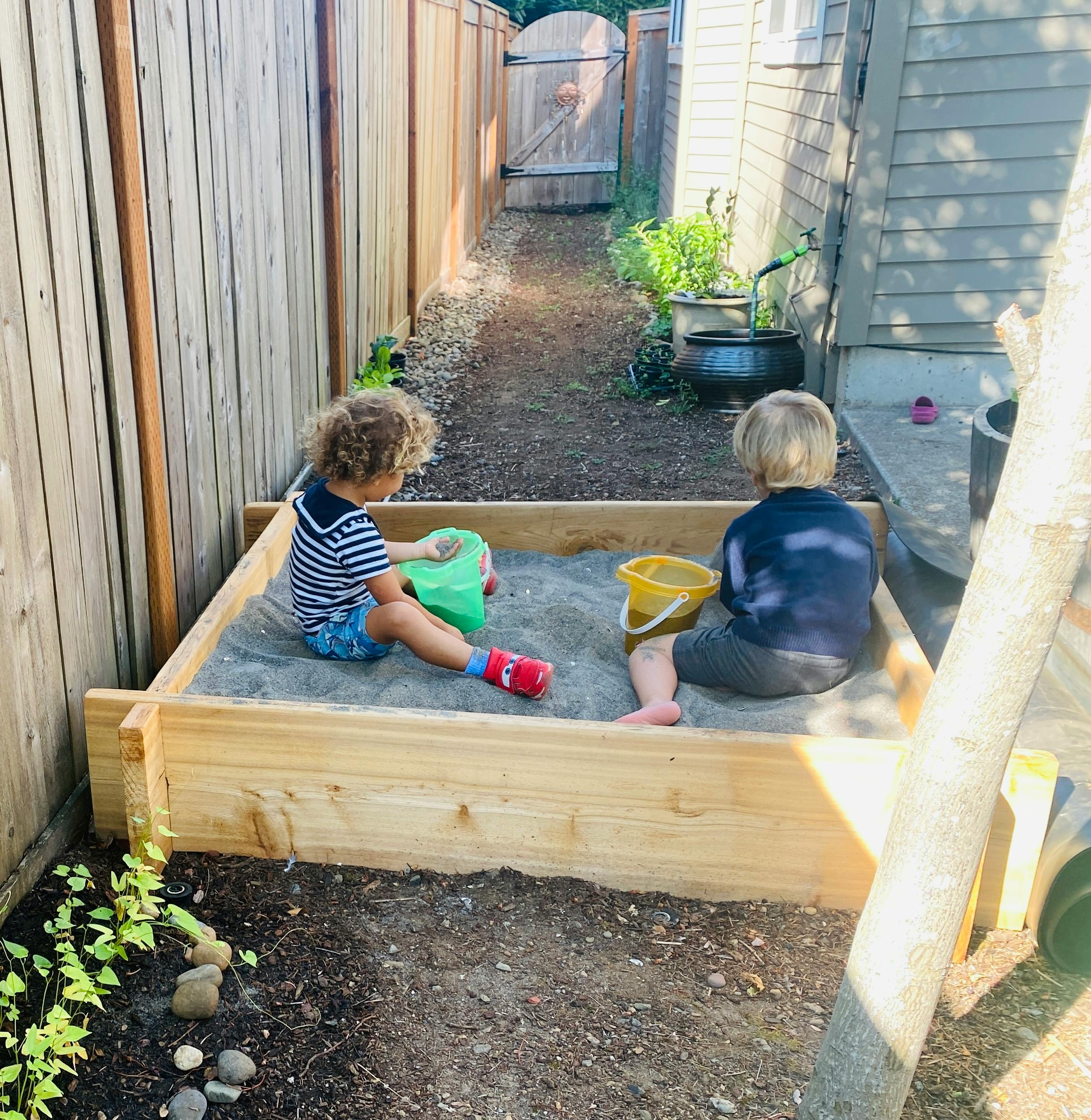 Two children playing in a sandbox