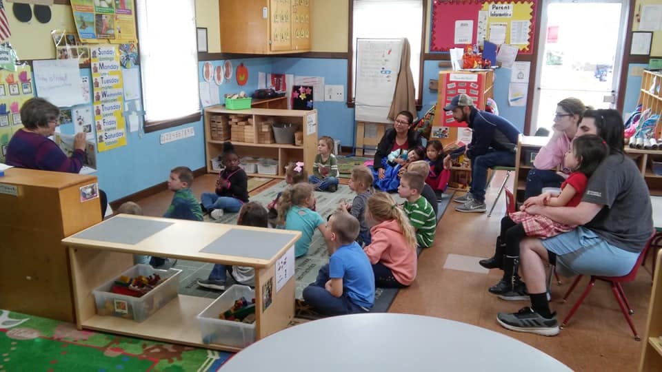 Adult reading to children in a classroom