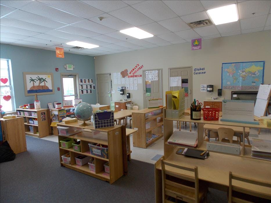 Classroom with small tables and chairs, shelves, and decorations on the walls