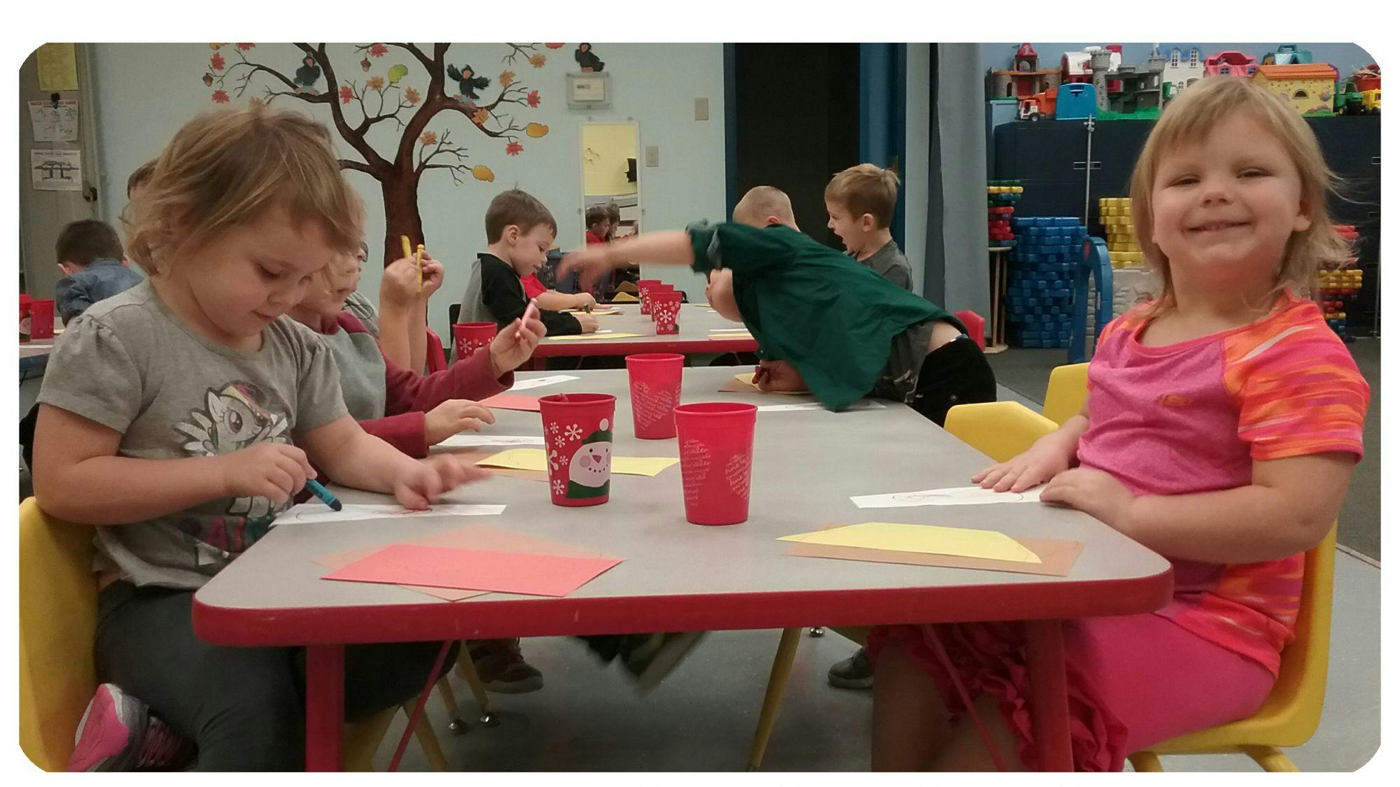 Children sitting at tables in a classroom