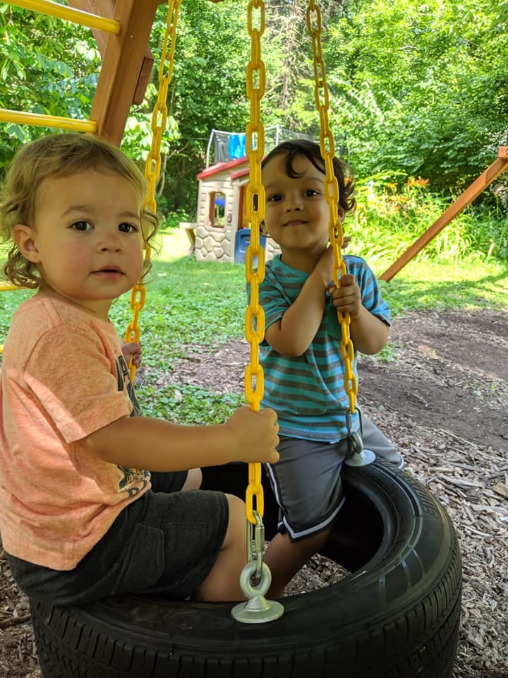Two children on a tire swing