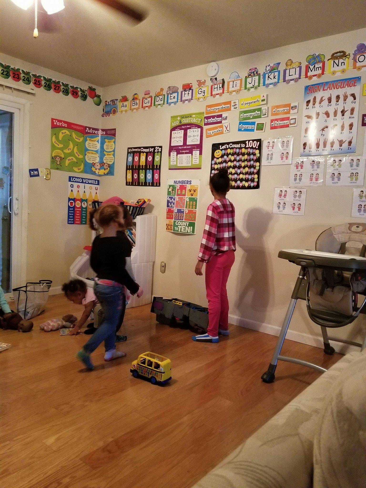 Children playing in a room with educational posters on the walls