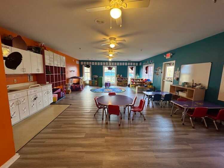 Classroom with small tables and chairs, storage units, and colorful walls