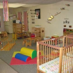 Empty nursery room with cribs and play equipment