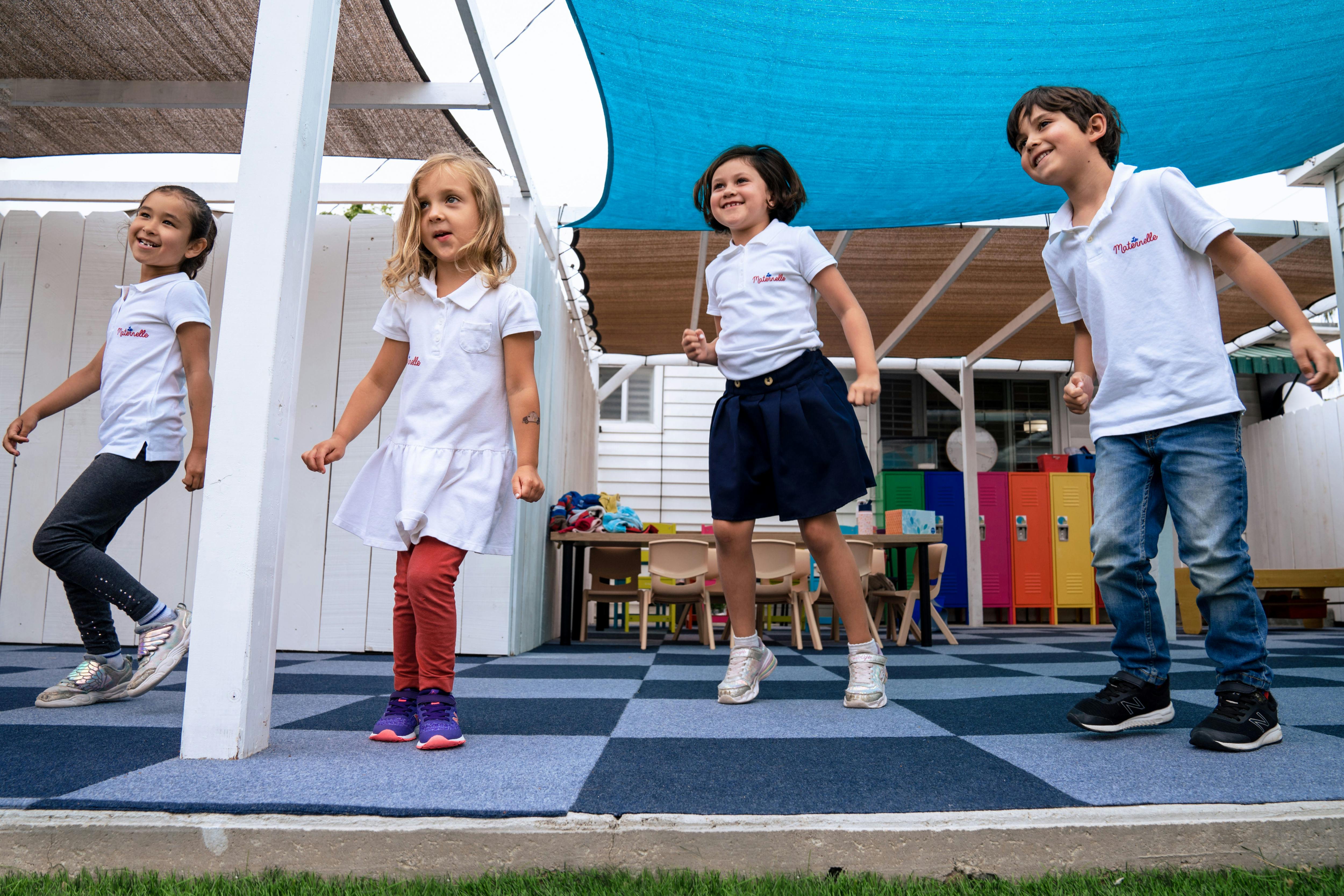 Four children standing on a checkered blue and black floor