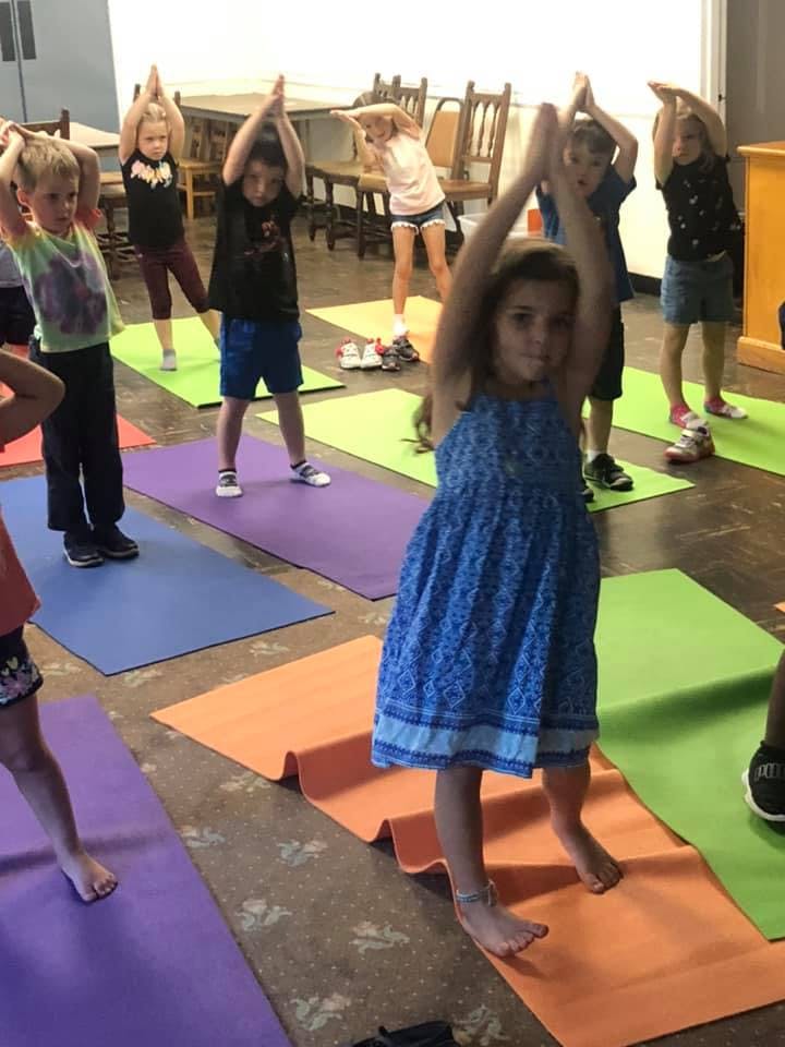 Children doing yoga poses on mats