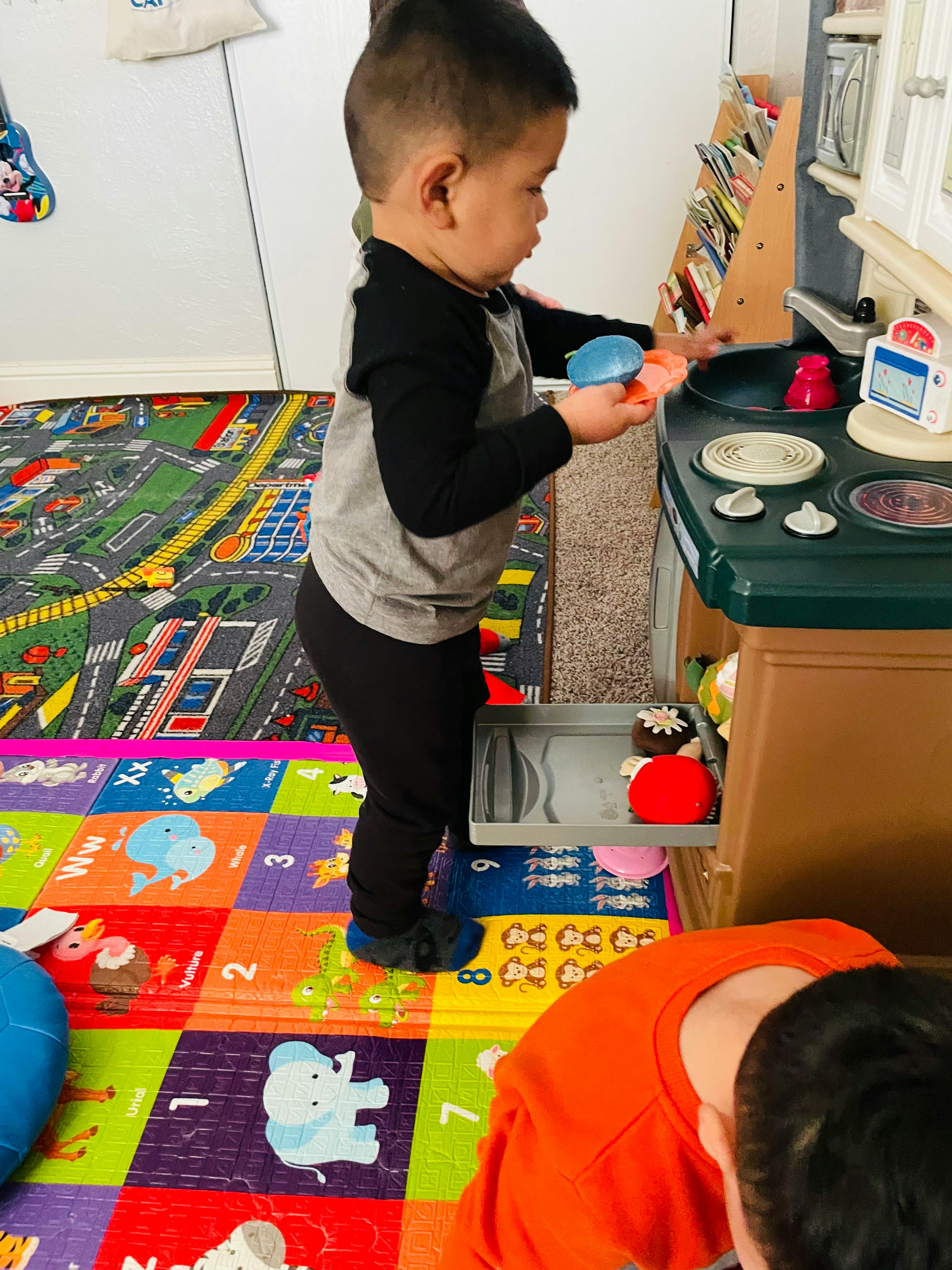 Child playing with a toy kitchen set