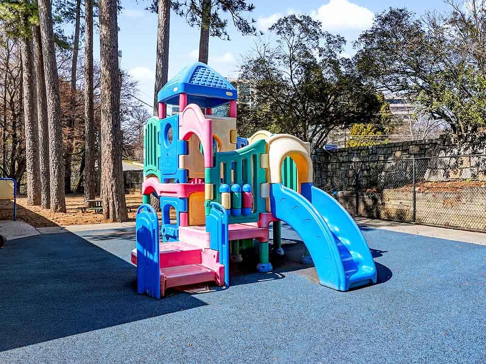 Colorful playground structure with slides on a blue soft surface