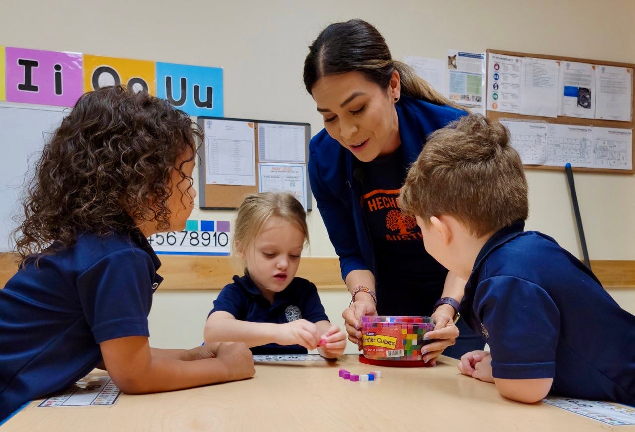 Adult and two children at a table with play-doh