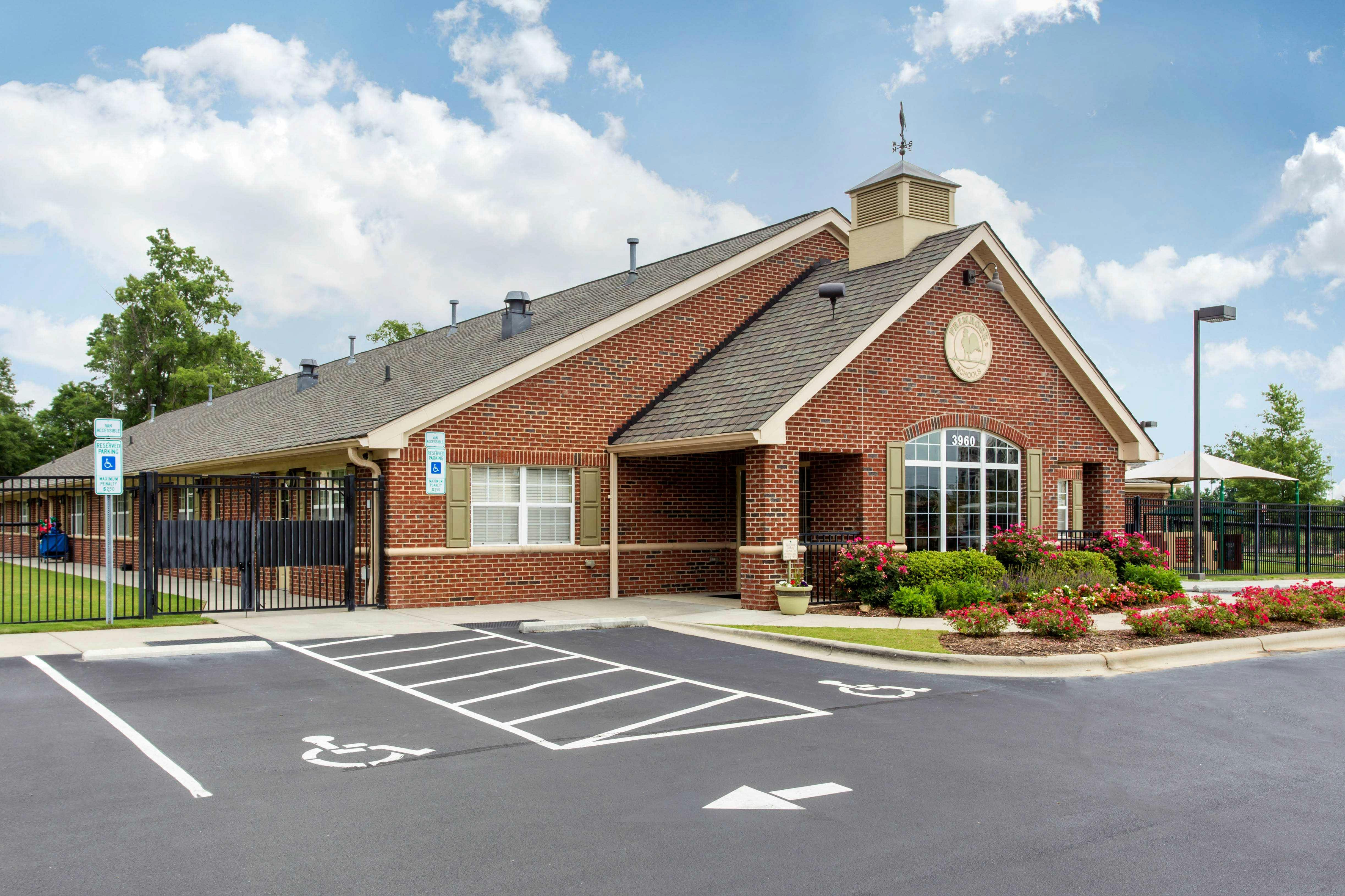 Brick building with a parking lot and landscaped entrance