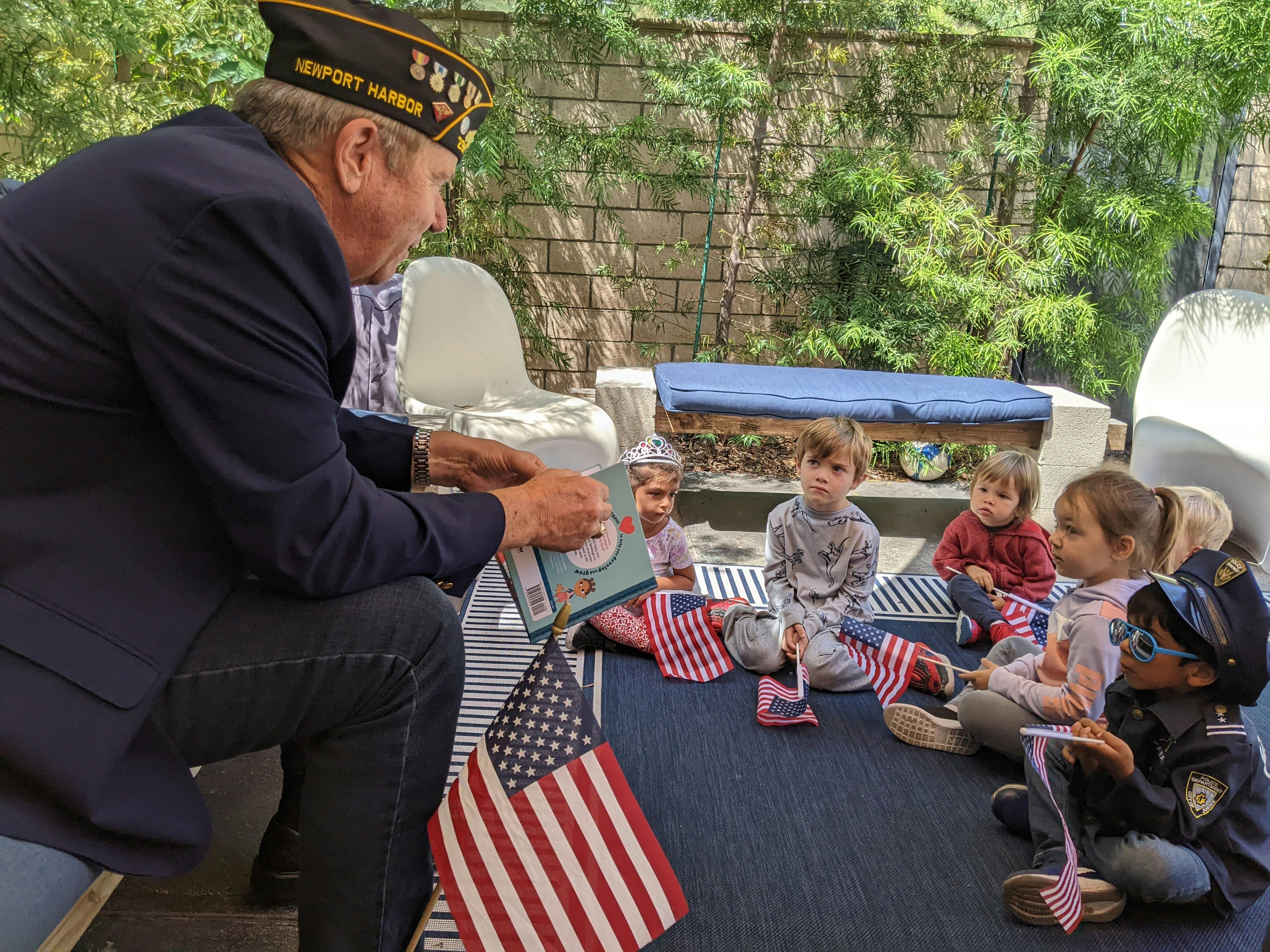 Person in uniform reading a book to a group of children