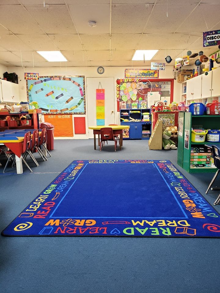 Classroom with a blue rug, tables, and colorful decorations