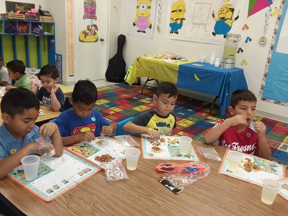 Children sitting at a table eating snacks