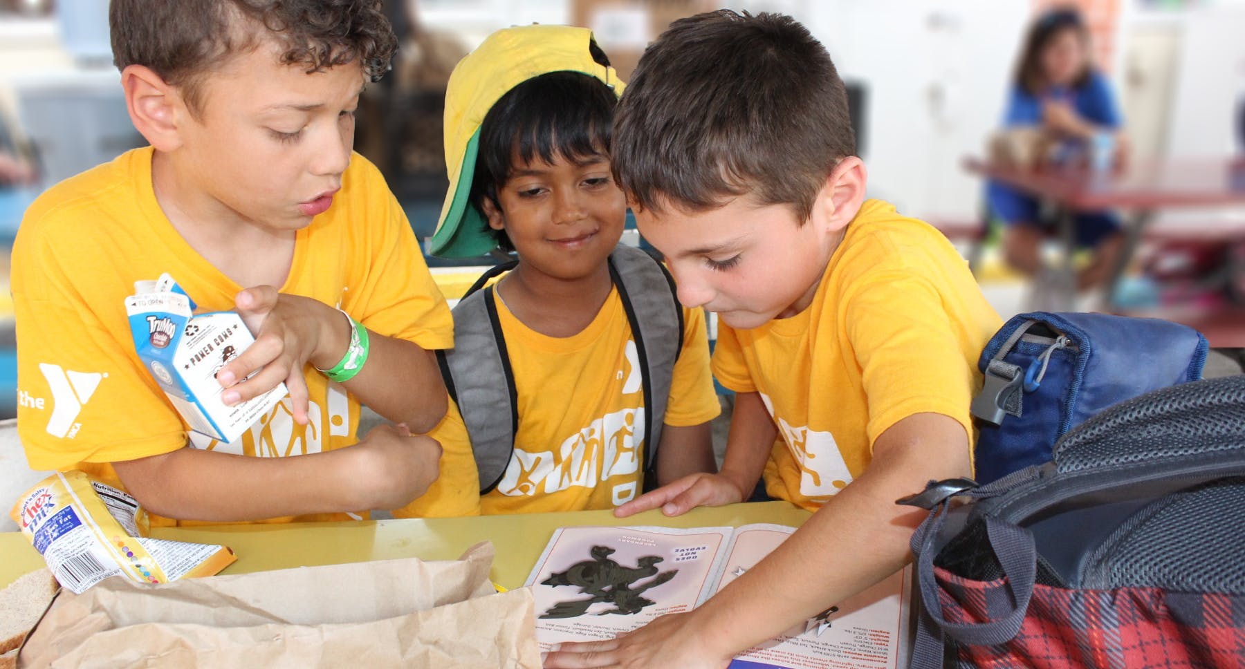 Three children looking at a drawing on a table