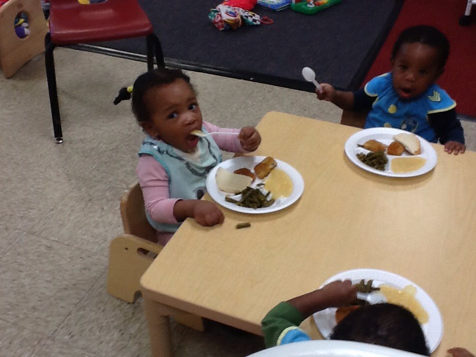 Three children eating meals at a table