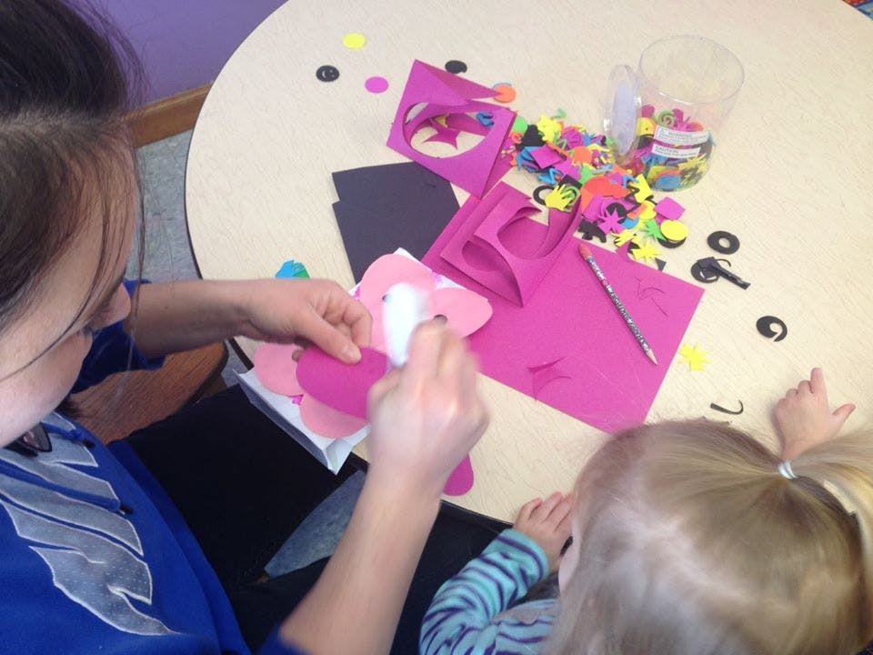 Person and child doing crafts at a table
