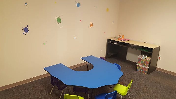 Classroom with blue U-shaped table and colorful chairs