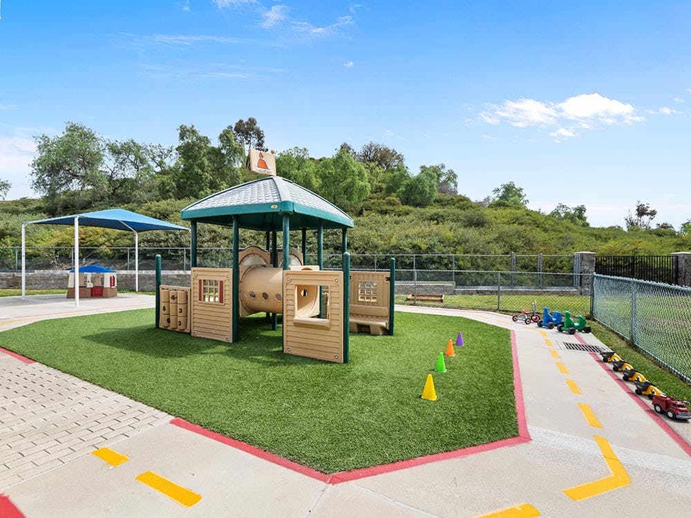 Playground with a climbing structure, sandbox, and toy vehicles