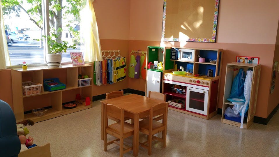 Playroom with small table and chairs, toy kitchen, and shelves
