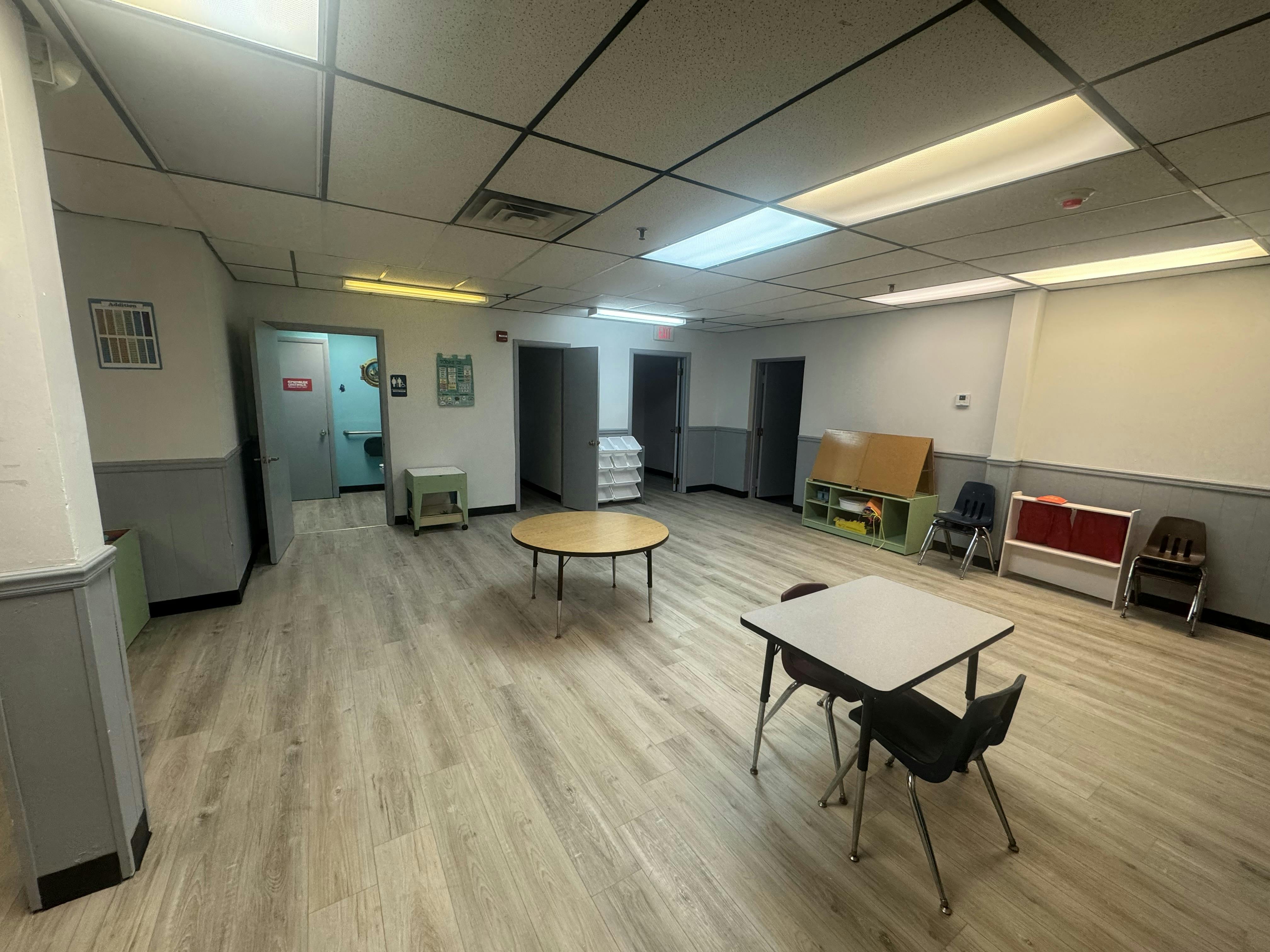 Empty classroom with small tables and chairs