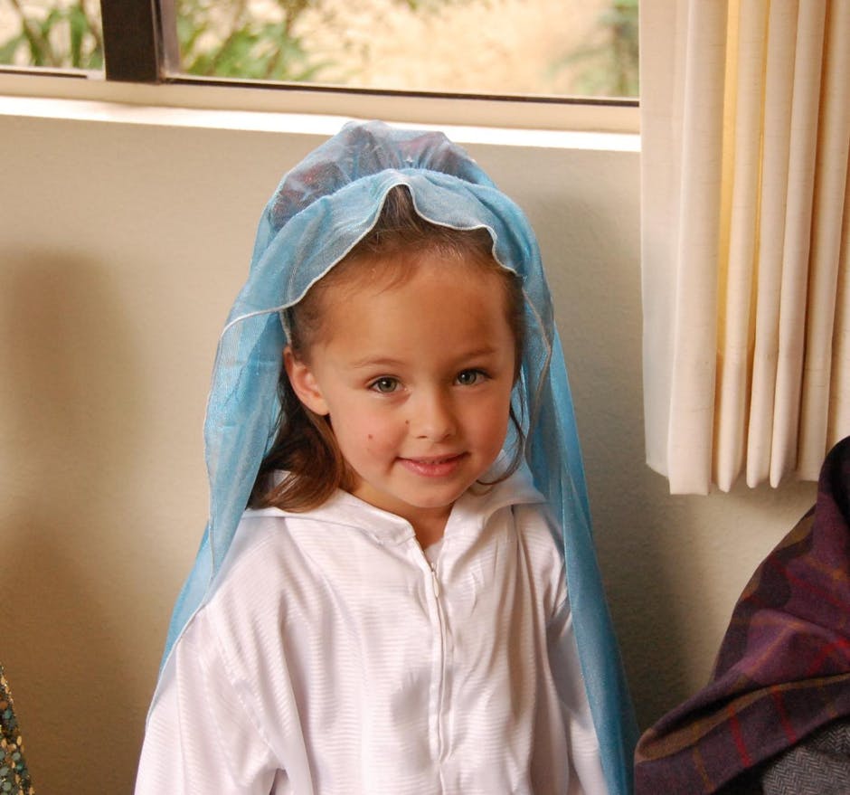 Child wearing a white robe and blue veil