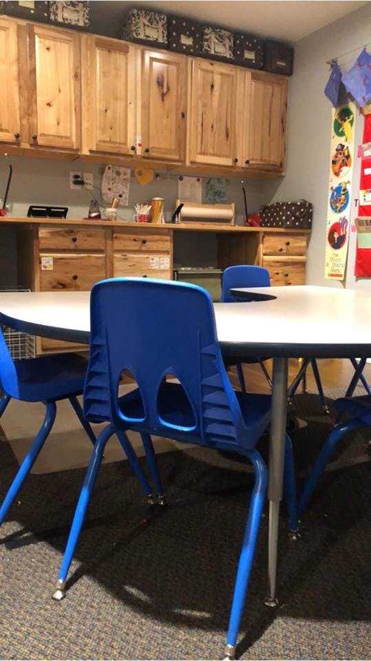 Classroom with blue chairs and wooden cabinets