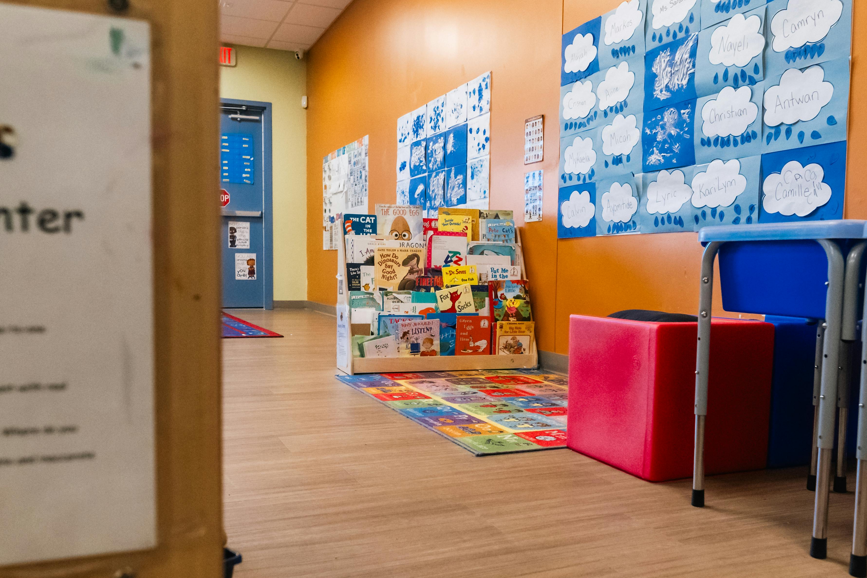 Children's books in a wooden display shelf in a classroom