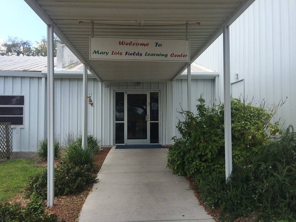 Walkway leading to a building entrance with a sign that reads "Welcome to Mary Cates Fields Learning Center"