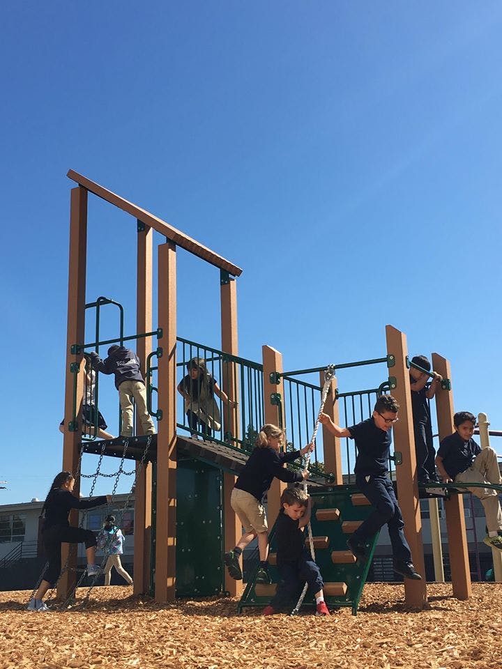 Children playing on a wooden playground structure