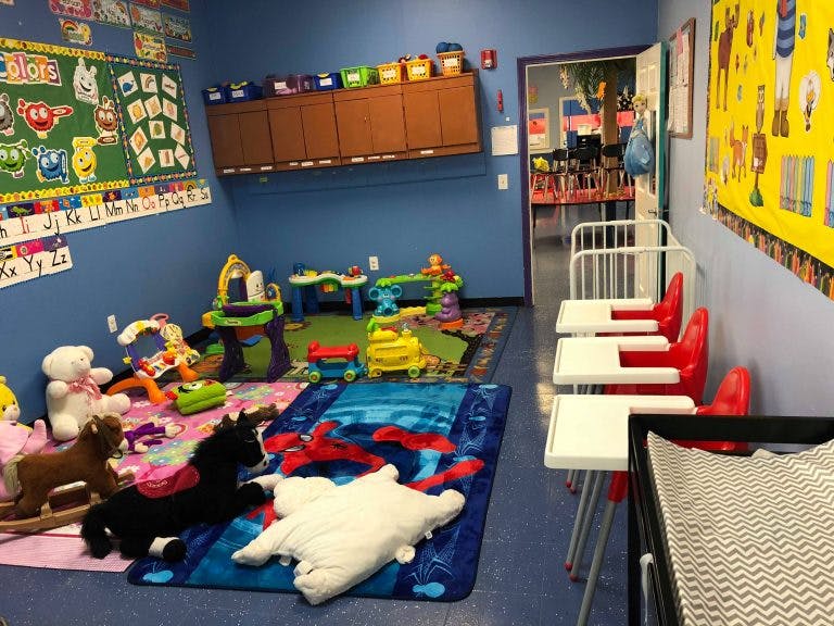 Playroom with toys, mats, and high chairs