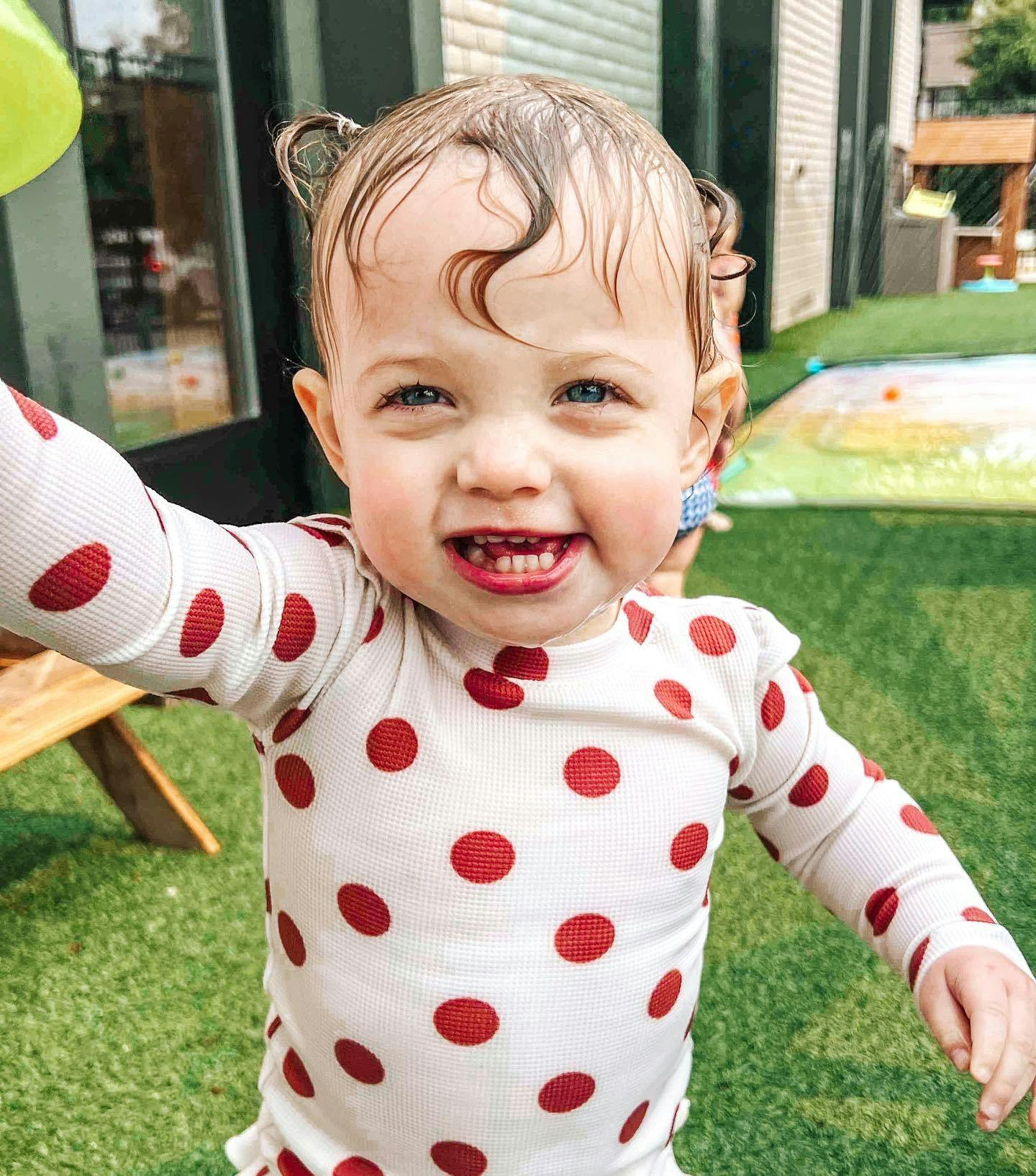 Child with wet hair in a polka dot shirt