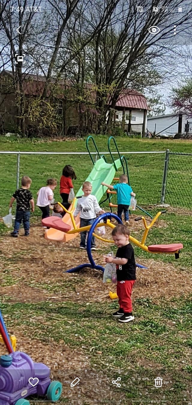 Children playing on a playground with a slide and seesaw