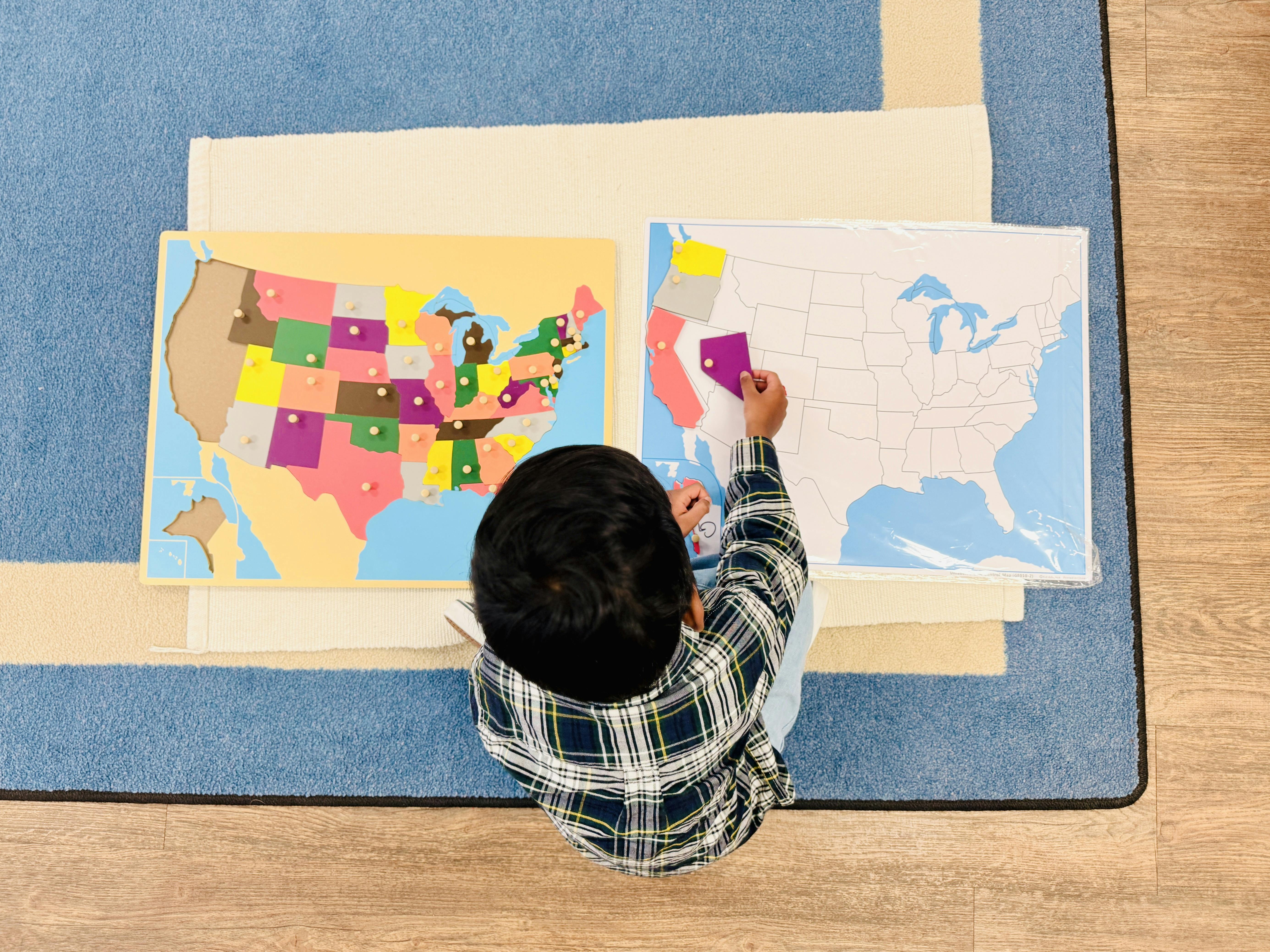 Child placing a state puzzle piece on a US map board