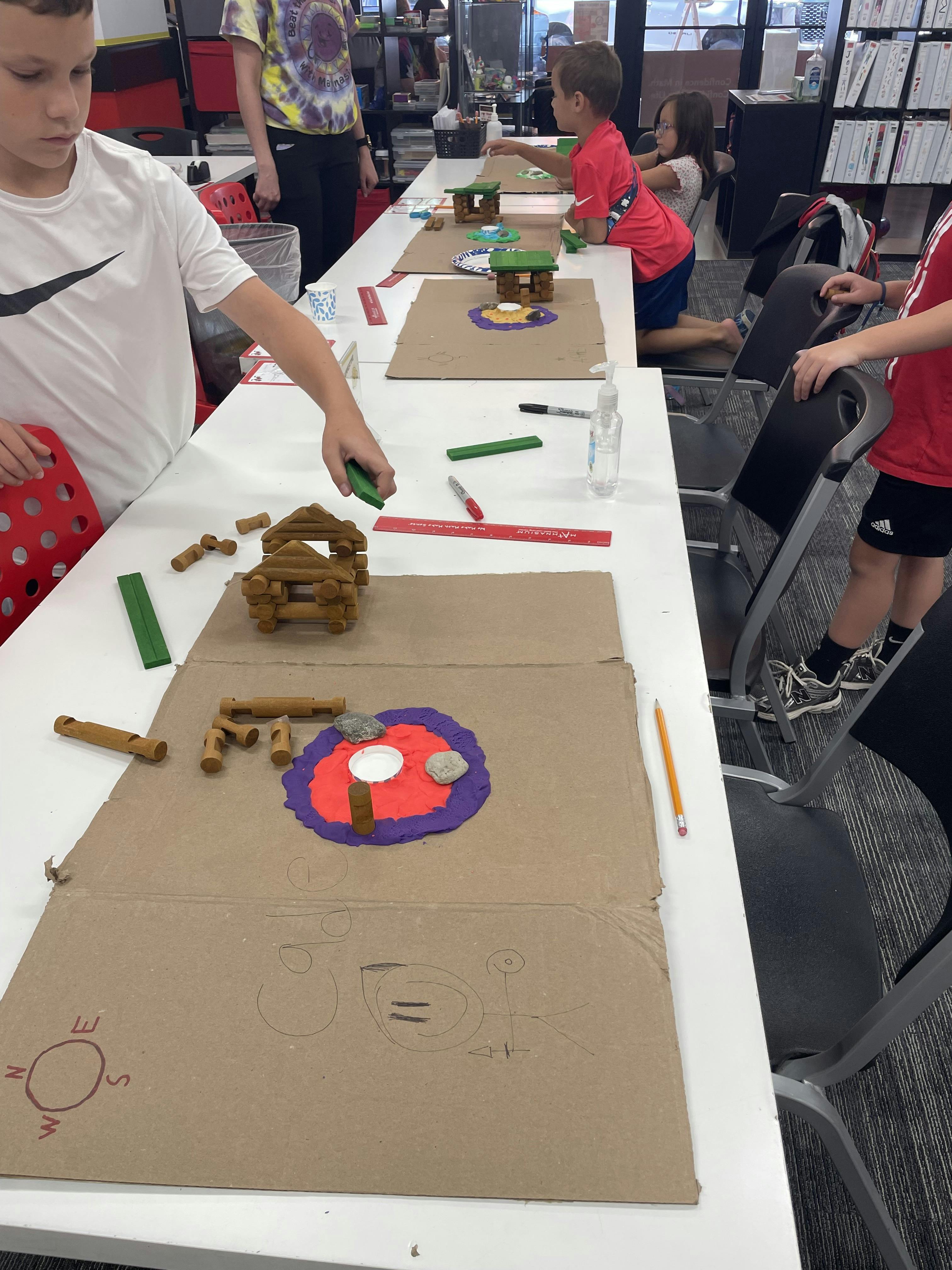 Children working on craft projects at a long table