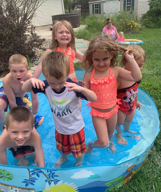 Children playing in a small inflatable pool outdoors