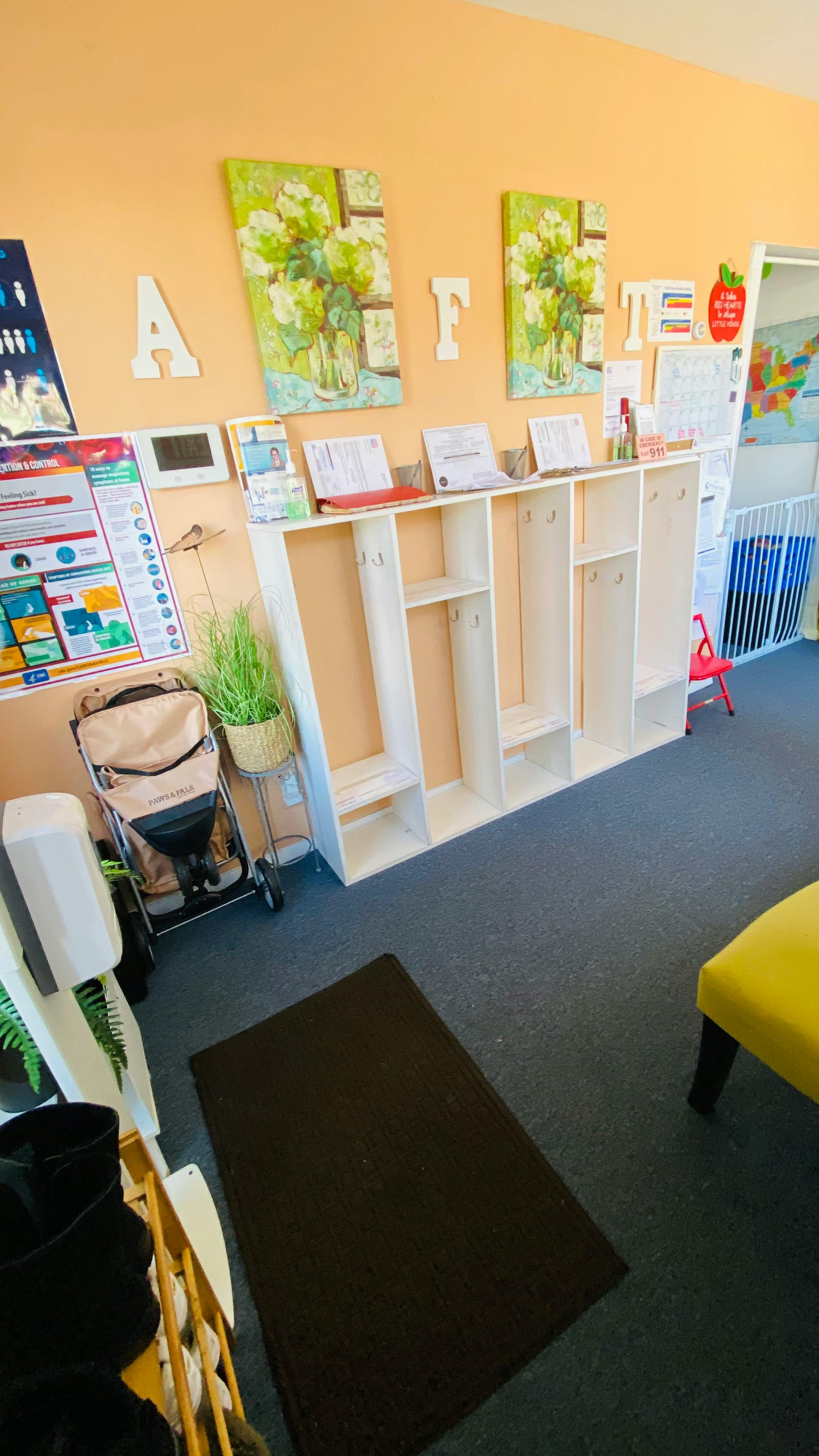 Classroom with cubbies, stroller, and wall decorations