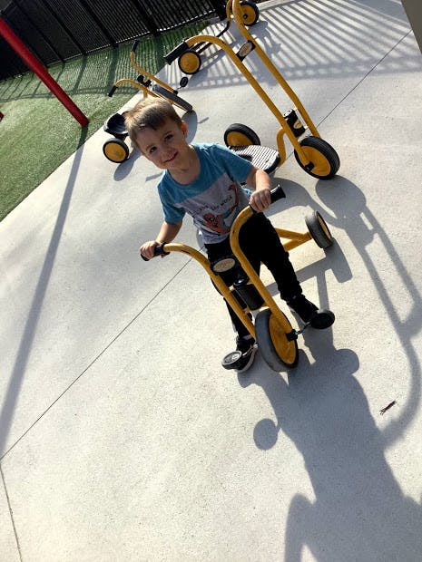 Child on a yellow tricycle