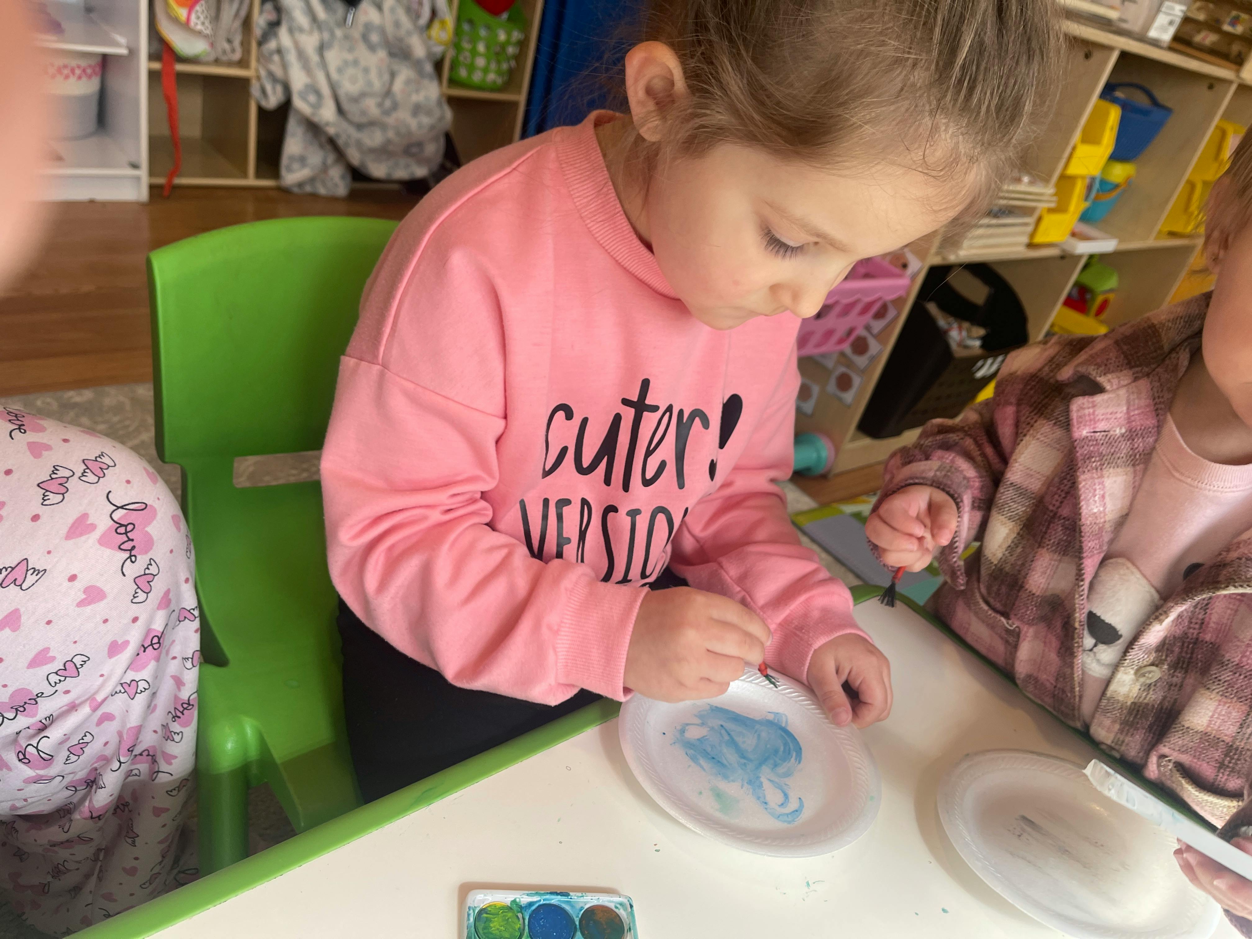 Child painting on a paper plate
