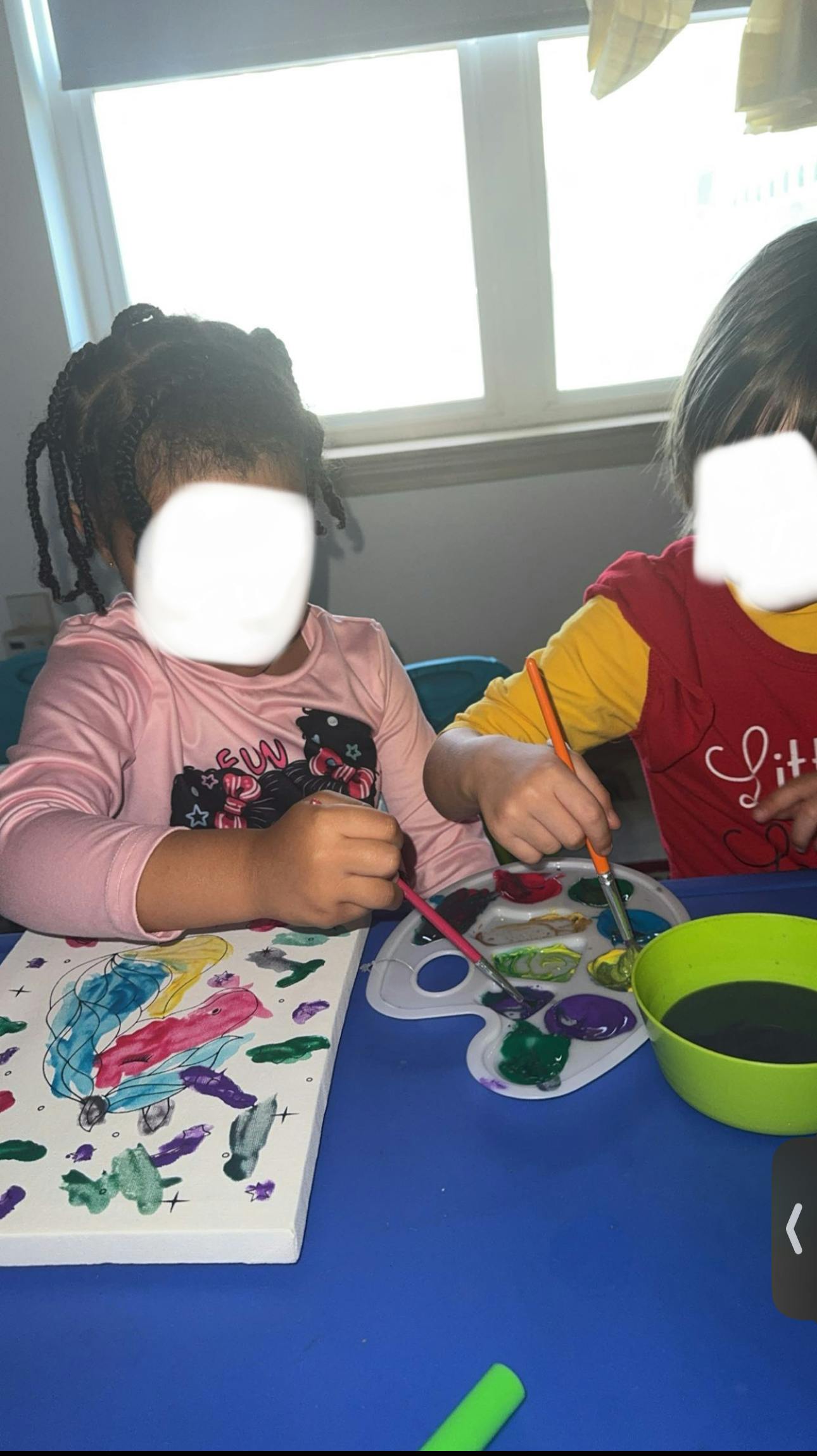 Two children painting at a table
