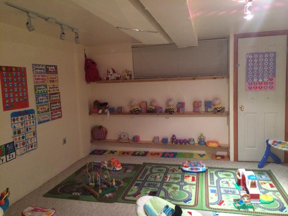 Playroom with shelves of toys and playmats on the floor