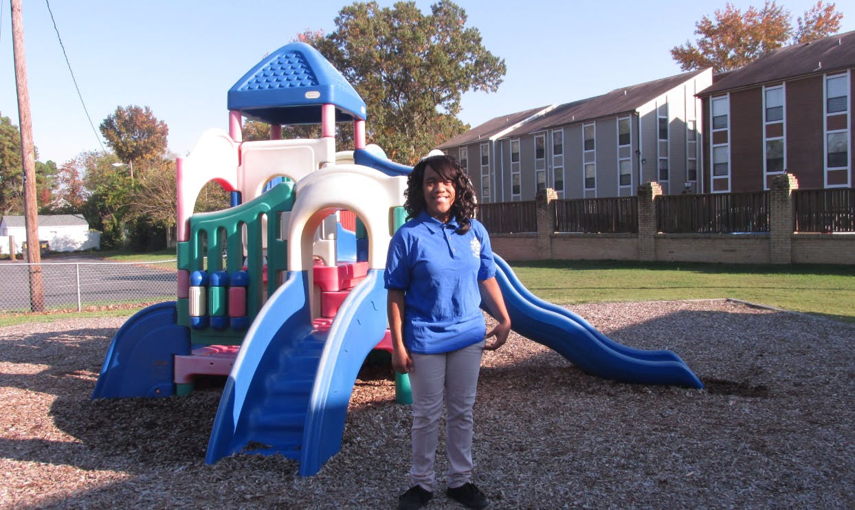Person standing in front of a playground structure with slides on a playground