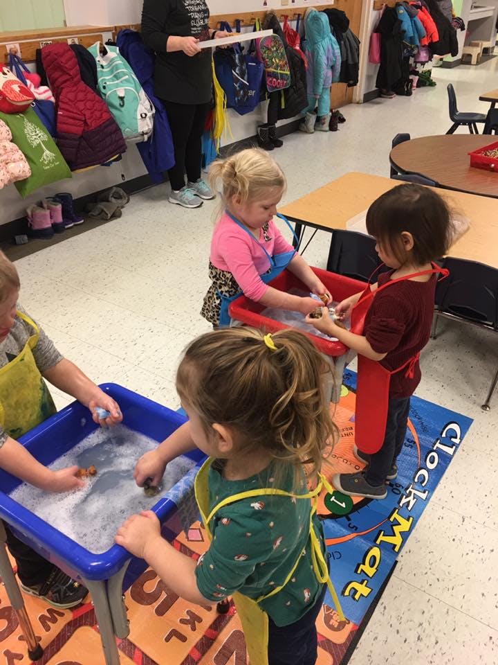 Children playing with water and bubbles in a classroom