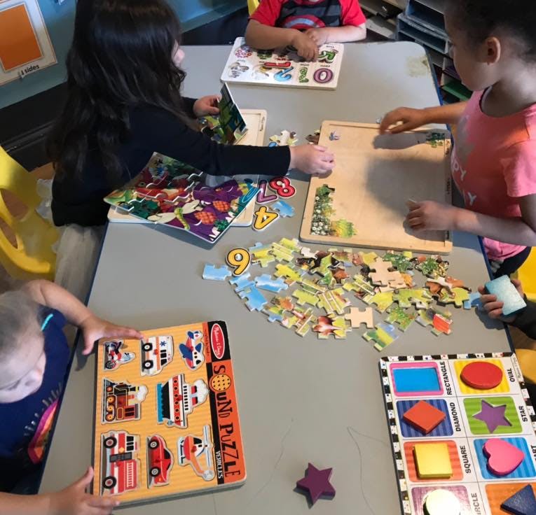 Children playing with puzzles at a table