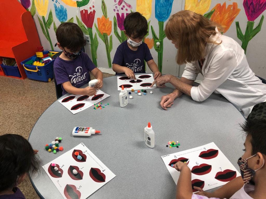 Adult and children doing crafts at a table