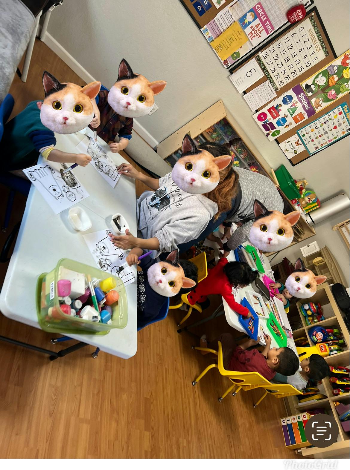 People wearing cat masks sitting at tables in a classroom