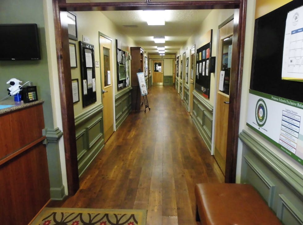 Long hallway with wooden floors and doors lining both sides