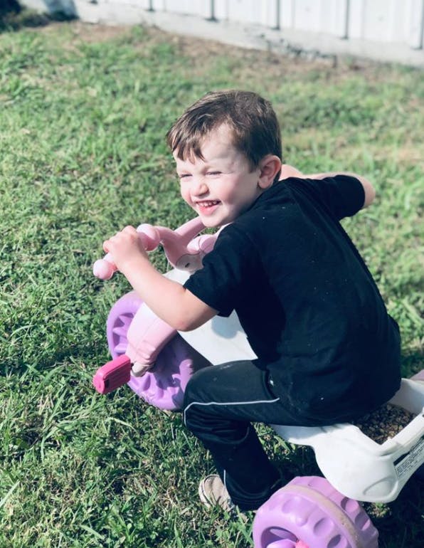 Child on a toy ride-on in grass