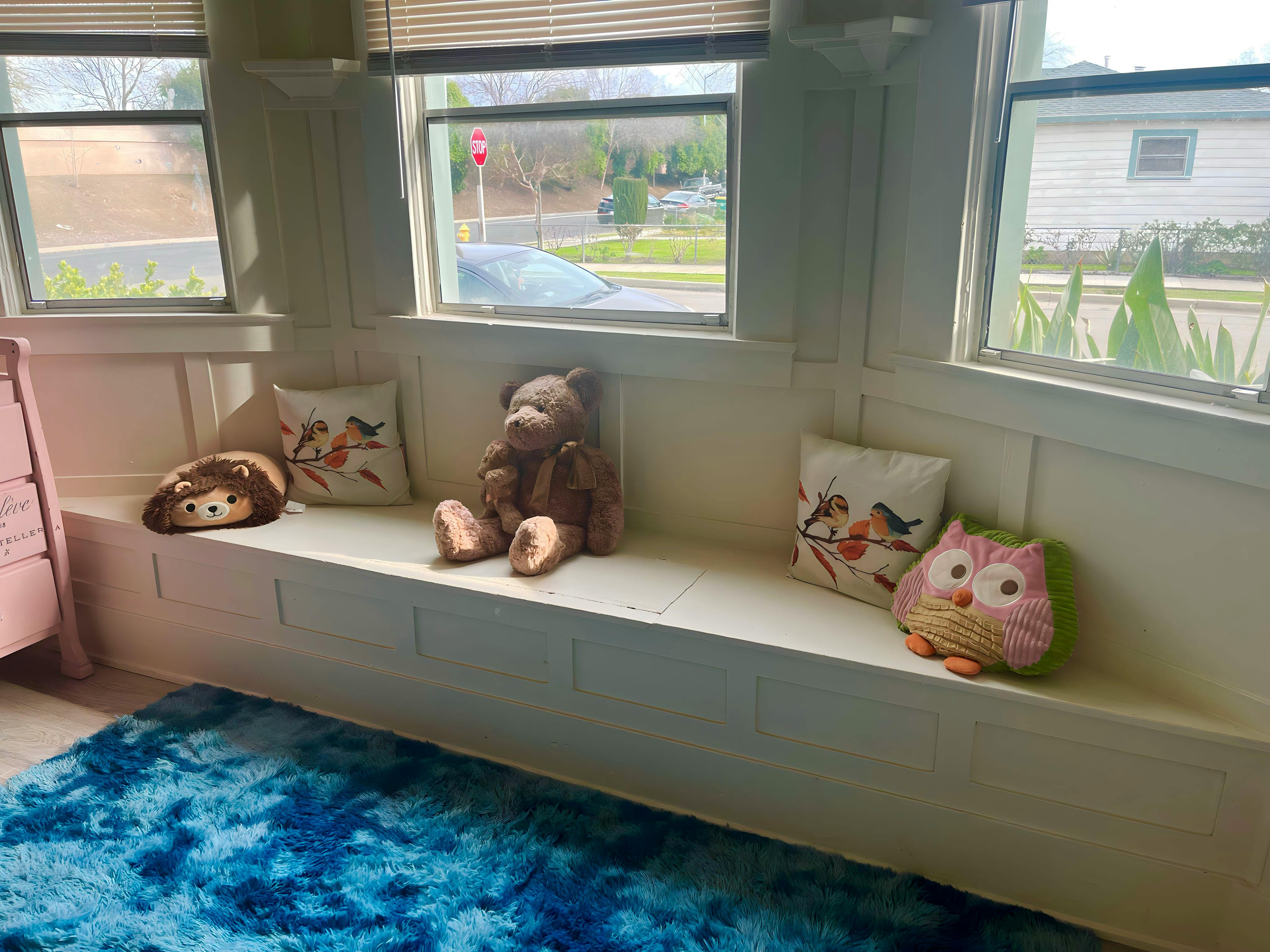 Stuffed animals and pillows on a window seat