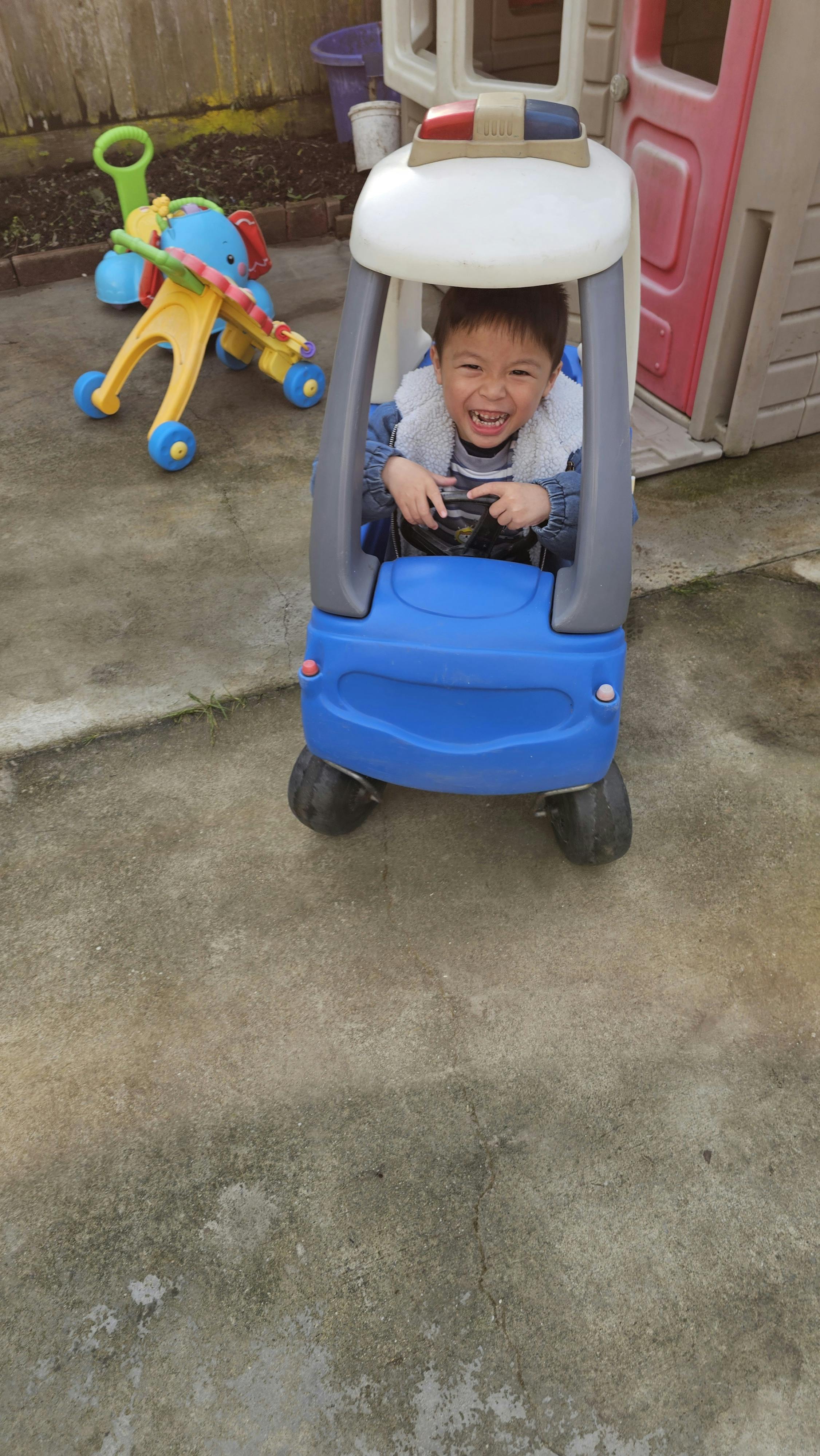Child in a toy police car